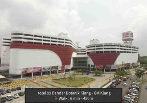 a large red and white building with a parking lot at Hotel 99 Botanik Klang in Klang
