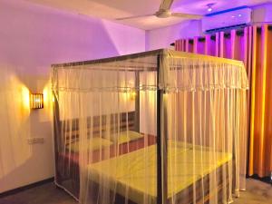 a bird cage in a room with purple lights at Kumara villa in Hikkaduwa
