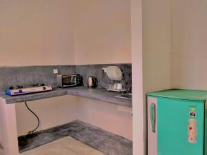 a kitchen with a blue refrigerator and a microwave at Kumara villa in Hikkaduwa +63 photos