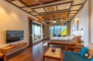 a bedroom with a bed and a tv in a room at The Wild Sakura in Mukteshwar