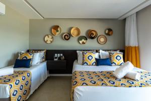 two beds in a room with clocks on the wall at Pousada de Charme Refugio da Villa - Pé na Areia in Porto De Galinhas +127 photos