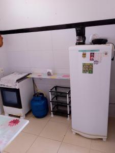 a small refrigerator and a table in a room at Quarto Soleil in Aracaju