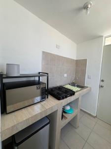 a kitchen with a counter top with a microwave at Equipped house in Salinas industrial zone in Ciudad Satelite del Norte +3 photos