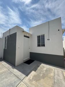 a white building with a garage and a sky at Equipped house in Salinas industrial zone in Ciudad Satelite del Norte
