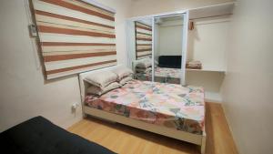 a small bedroom with a bed and a mirror at Janice Place 2 in Marilao
