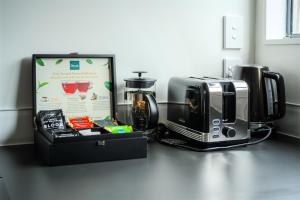 a counter with a coffee maker and a microwave at Te Awa Suites in Hamilton +15 photos