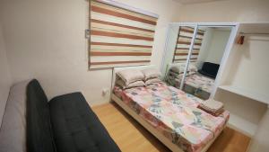 a small bedroom with a bed and a mirror at Janice Place 2 in Marilao +14 photos