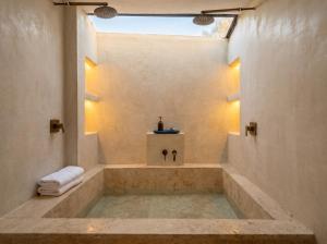 a bathroom with a bath tub with a sink at Zihua Mia Hotel Boutique in Zihuatanejo