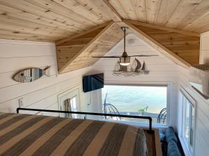 a bedroom in a tiny house with a large window at The River's Edge (Tiny Home 3) in Bellevue