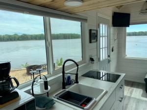 a kitchen with a sink and a view of the water at The River's Edge (Tiny Home 3) in Bellevue