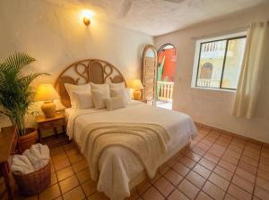a bedroom with a large bed and a window at Zihua Mia Hotel Boutique in Zihuatanejo