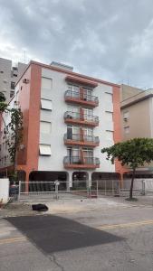 a white building with balconies on the side of it at Apê Completo - 300m da Praia in Guarujá