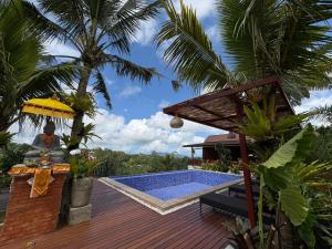 a resort with a pool and a statue on a deck at Artala Villa & Restaurant in Besakih