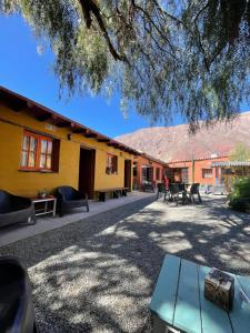 a building with chairs and tables in a courtyard at Casa los Molles Hostel in Maimará