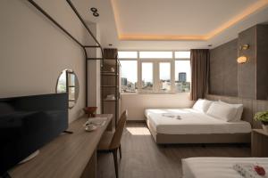 a hotel room with a bed and a tv at The Cozy Hotel in Ho Chi Minh City