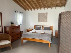 a bedroom with a bed and a chair in it at Rustica Ocean View House in Bretanha