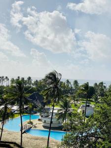 a view of the pool at the resort with palm trees at Wanderlust at Golden Sun in Diani Beach