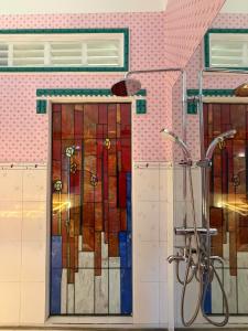 a bathroom with stained glass doors and a shower at Út Pink in Ấp Xuân Sơn