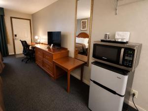 a hotel room with a microwave and a desk at Ozark Inn & Suites in Ozark