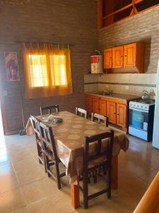 a kitchen with a table with chairs and a stove at Cabañas Frago in Villa Amancay
