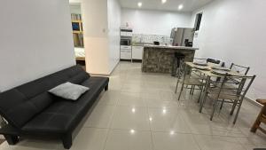 a living room with a couch and a table and a kitchen at Casa en cineguilla in Cieneguilla