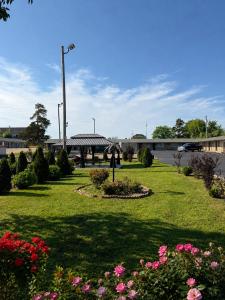 a park with flowers and a bridge in the background at Ozark Inn & Suites in Ozark