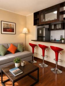 a living room with a couch and red bar stools at Departamentos Amoblados Torre Tagle in Santiago