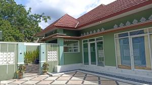 a green house with a red roof at Nanda Harum Villa in Sangyang