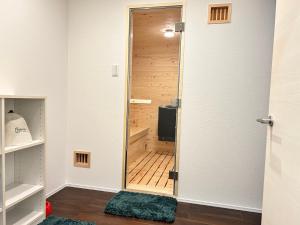 a room with a closet with a wooden door at 南アルプスを望むサウナ付き宿,田園風景,全室エアコン,バーベキュー可 in Hokuto +28 photos