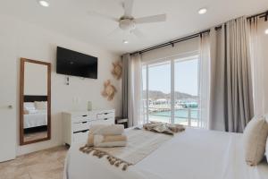 a bedroom with a large bed and a large window at Suites La Playa in Santa Cruz Huatulco