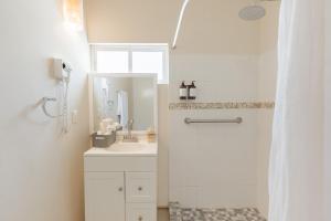 a white bathroom with a sink and a shower at Suites La Playa in Santa Cruz Huatulco +77 photos