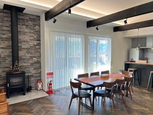 a dining room with a table and chairs and a fireplace at 南アルプスを望むサウナ付き宿,田園風景,全室エアコン,バーベキュー可 in Hokuto