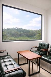 a waiting room with chairs and a table and a large window at B'lao Eco Lodge in Bảo Lộc