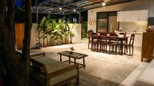 a living room with chairs and a table and a kitchen at Mimi House in Hoi An