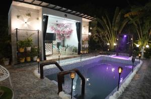 a swimming pool with lights in a house at night at The White Lilly in Noida
