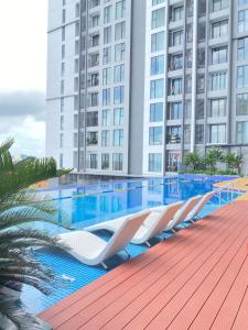 a row of lounge chairs next to a swimming pool at Green Chill Studio in An Khê