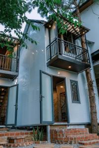 a house with glass doors and a balcony at Angels Homestay & Coffee - Măng Đen in Kon Von Kla