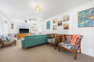 a living room with a blue couch and chairs at Mirrabooka in Lake Cathie