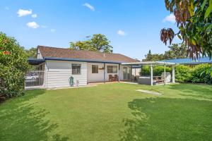 a house with a large yard with a yard at Mirrabooka in Lake Cathie