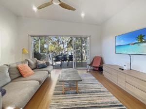 a living room with a couch and a flat screen tv at Pet-Friendly 3-Bed Coastal Gem Near Long Beach in Long Beach +21 photos