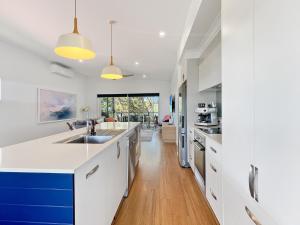 a kitchen with white cabinets and blue accents at Pet-Friendly 3-Bed Coastal Gem Near Long Beach in Long Beach