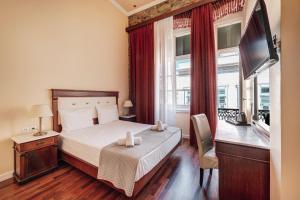a hotel room with a bed and a television at Hotel Aktaion Syros in Ermoupoli +79 photos