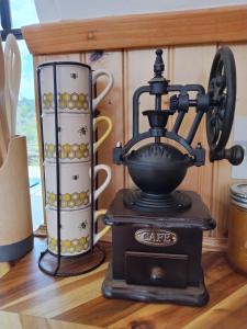 a coffee machine sitting on a table with two cups at Lava Bus in Hawaiian Ocean View