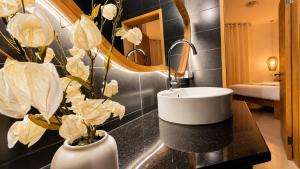 a bathroom with a sink and flowers on a counter at Villa Agata Mauritius in Mont Choisy +21 photos
