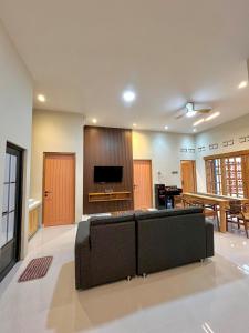 a living room with a couch and a flat screen tv at Lepen Home in Ngabean