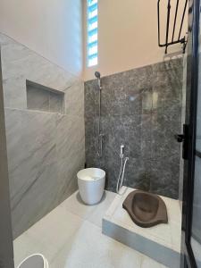 a bathroom with a shower and a toilet and a sink at Lepen Home in Ngabean +12 photos