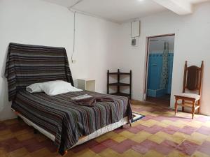 a bedroom with a bed with a striped blanket at Hotel casa de doña Rome in Chichicastenango +18 photos