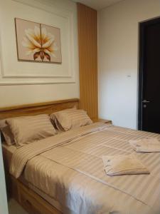 a bed in a bedroom with a picture of a flower at Shania home in Bogor