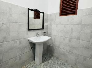 a bathroom with a sink and a mirror at Villa Dream D in Hikkaduwa