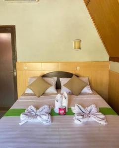 a bed with white towels and bows on it at meno smile cottages 2 in Gili Meno
